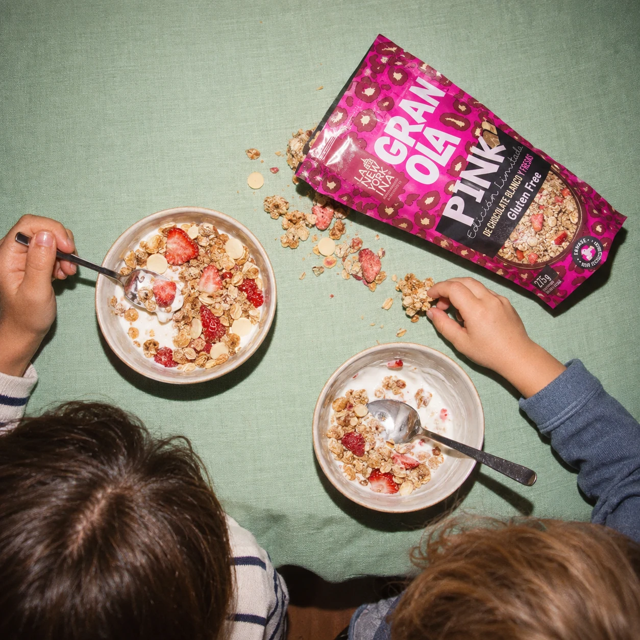 Granola Pink de La Newyorkina junto a dos boles de yogur y fresas